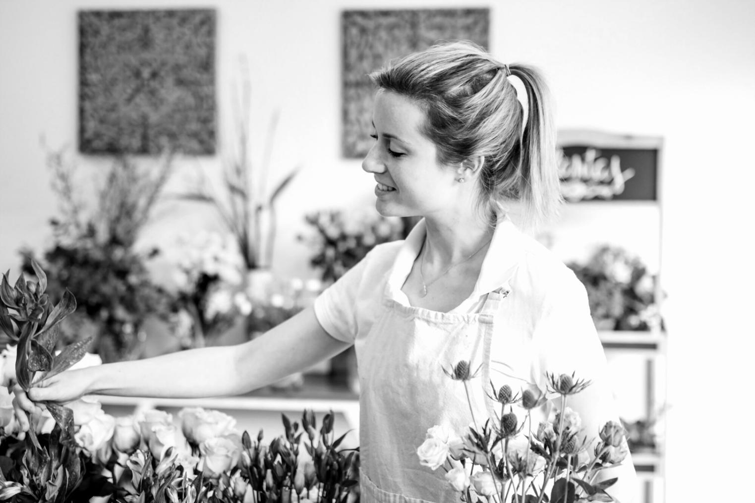 Professional floral arrangement workspace with various tools and fresh flowers being prepared for advanced floristry techniques